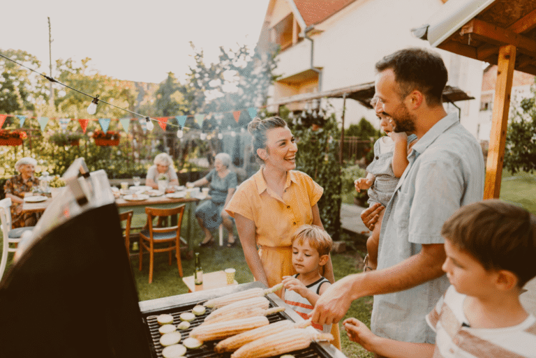 Family enjoying a backyard barbecue with friends and children.