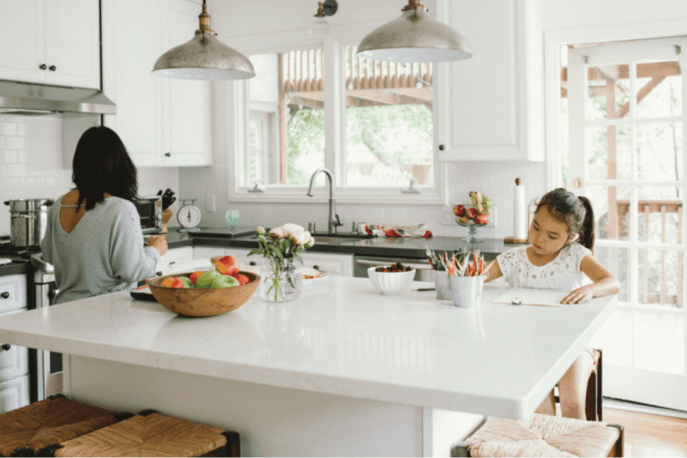 Family kitchen with a large island, bowls and jars for storage, and a child drawing at the bench