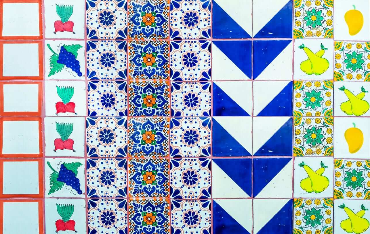 Colourful patterned tiles featuring geometric shapes and fruit motifs in blue, white and yellow.