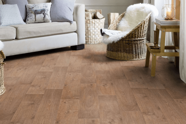 Living room with timber-look flooring, a sofa and woven chair.