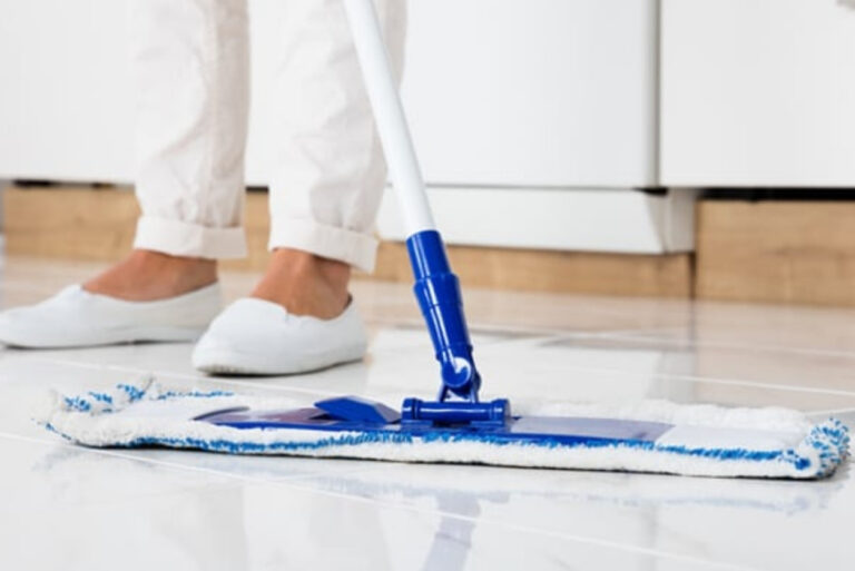 Close up of someone mopping floor tiles
