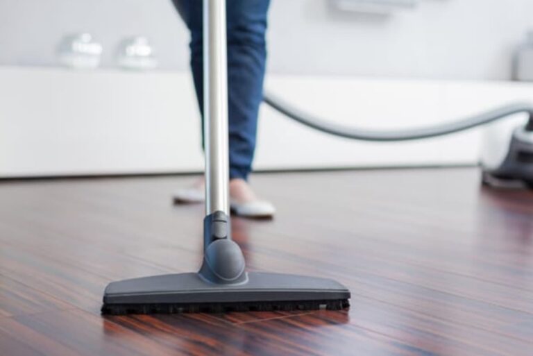 A person vacuuming timber flooring