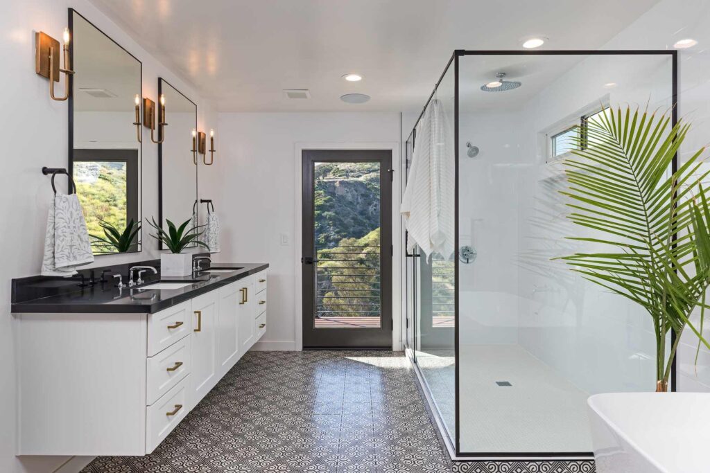 Bathroom featuring large shower stall, vanity and patterned tile flooring.
