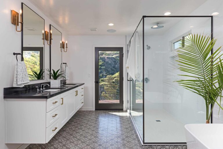 Bathroom featuring large shower stall, vanity and patterned tile flooring.