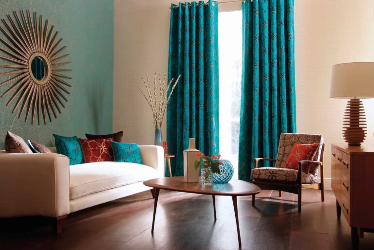 Contemporary living room with teal curtains, cream sofa, patterned armchair and wooden coffee table