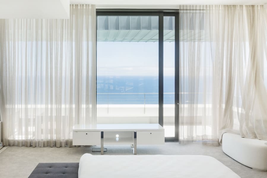 Large window with sheer curtains allowing natural light into the room.