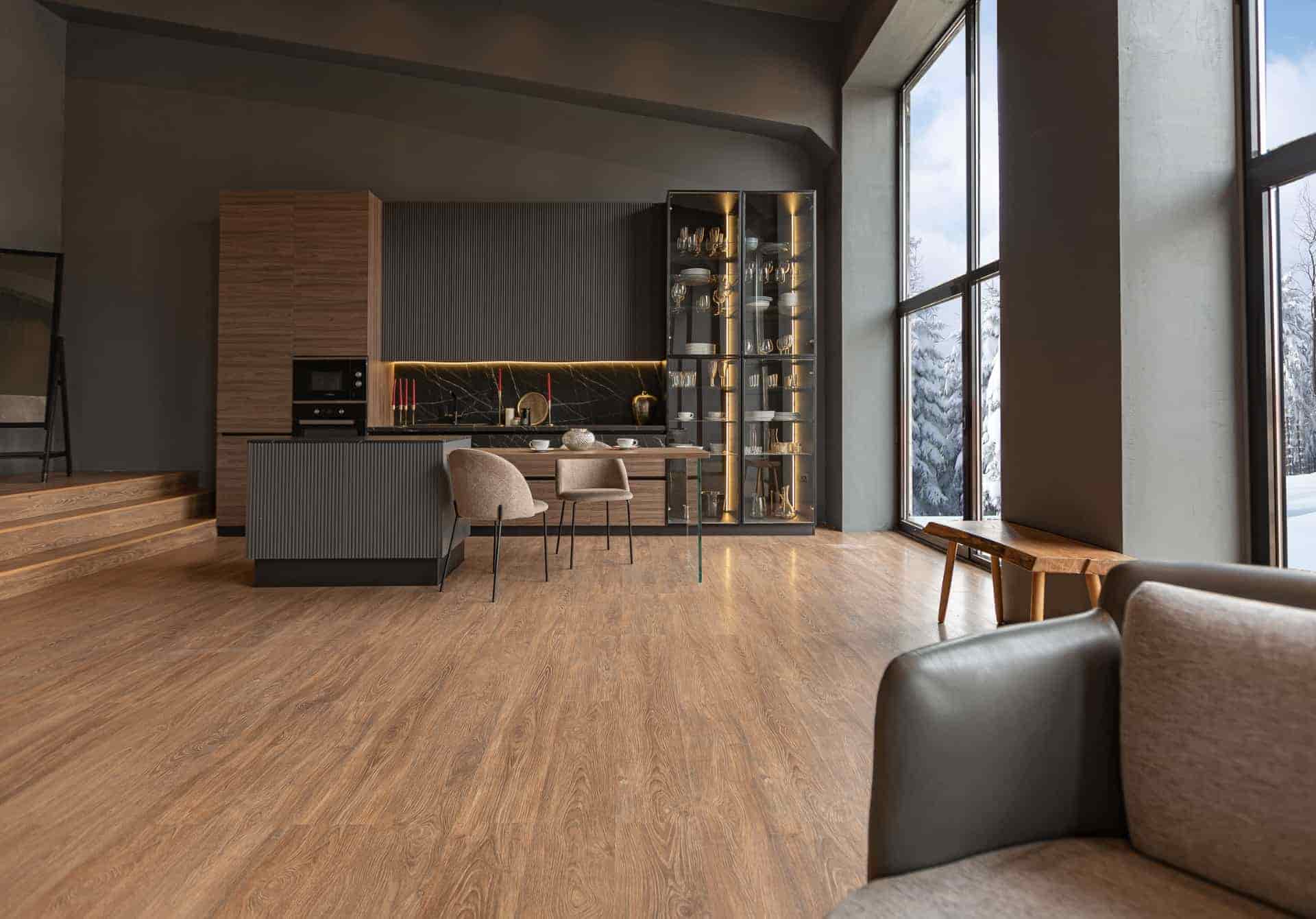 Modern kitchen and living space with wood-look laminate flooring and minimalist cabinetry