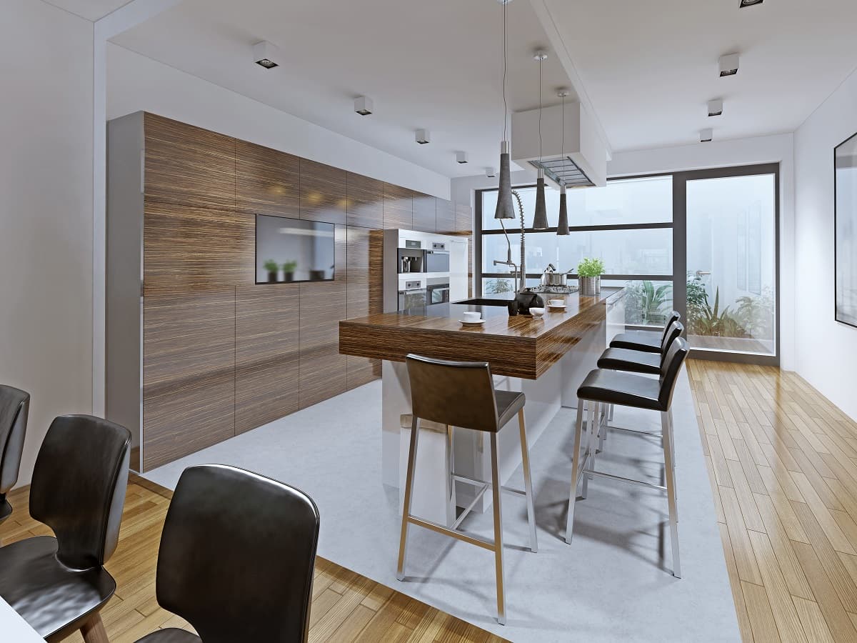 A kitchen with bamboo flooring, large island bench and sleek cabinetry.