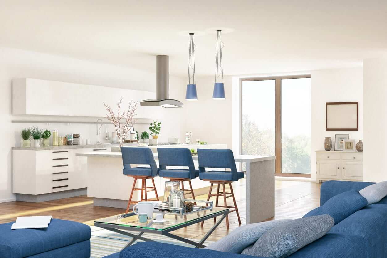 An open-plan kitchen with white cabinetry, a large island and blue upholstered bar stools