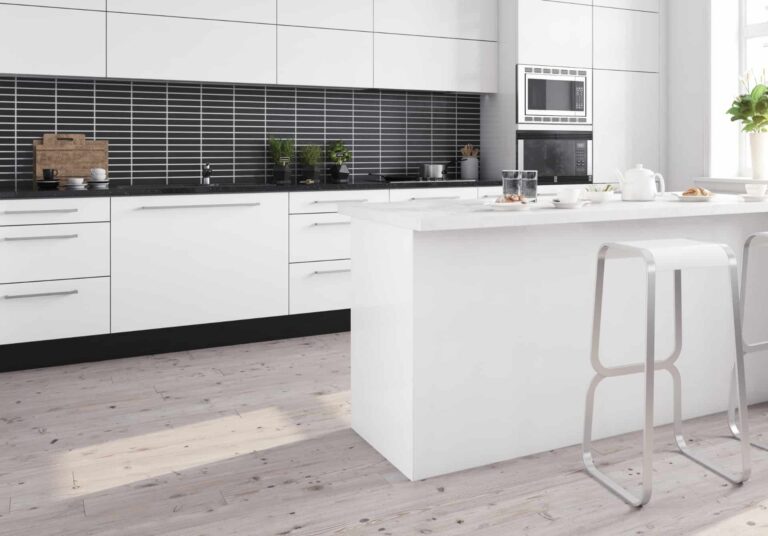 A kitchen featuring black splashback, white cabinets and countertops, and pale timber-look flooring