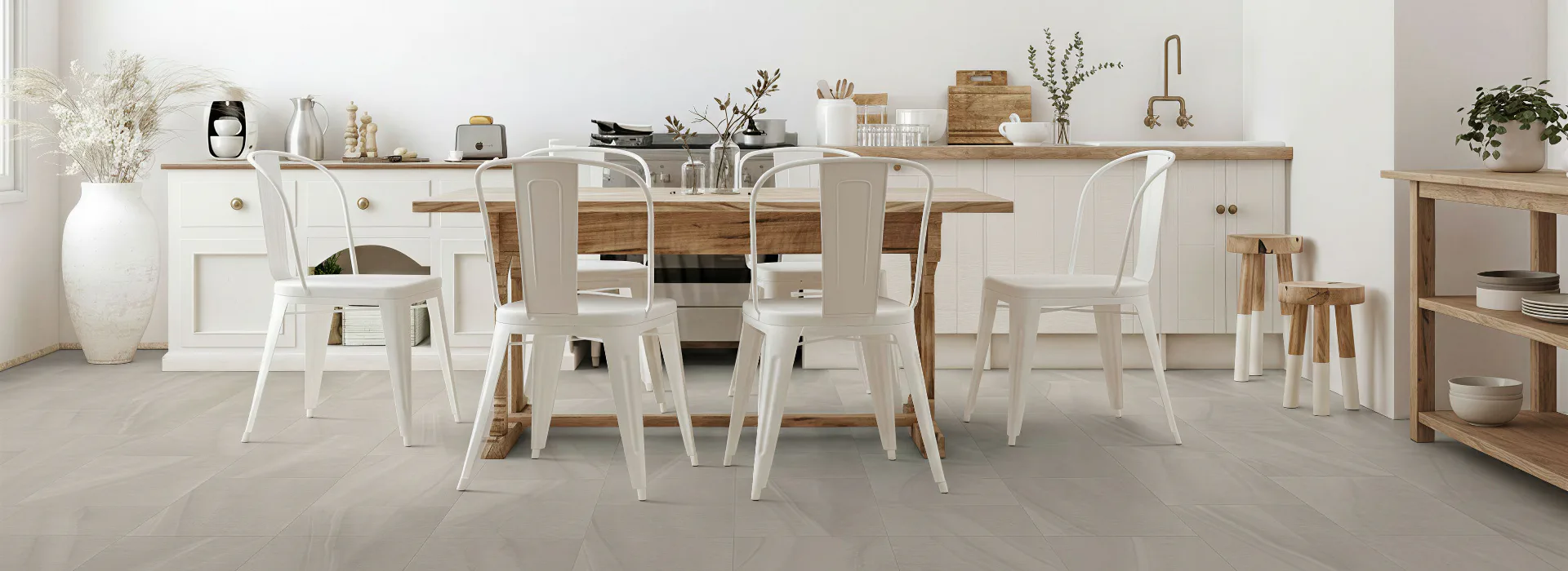 Contemporary kitchen and dining area featuring white metal chairs, natural wood table, white cabinetry, open shelving with décor, potted plants, and light gray sheet vinyl flooring throughout the s...