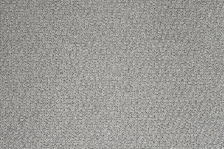 Close-up texture of gray woven carpet showing the dense, fine pile material in neutral tone with subtle depth and uniform weave pattern
