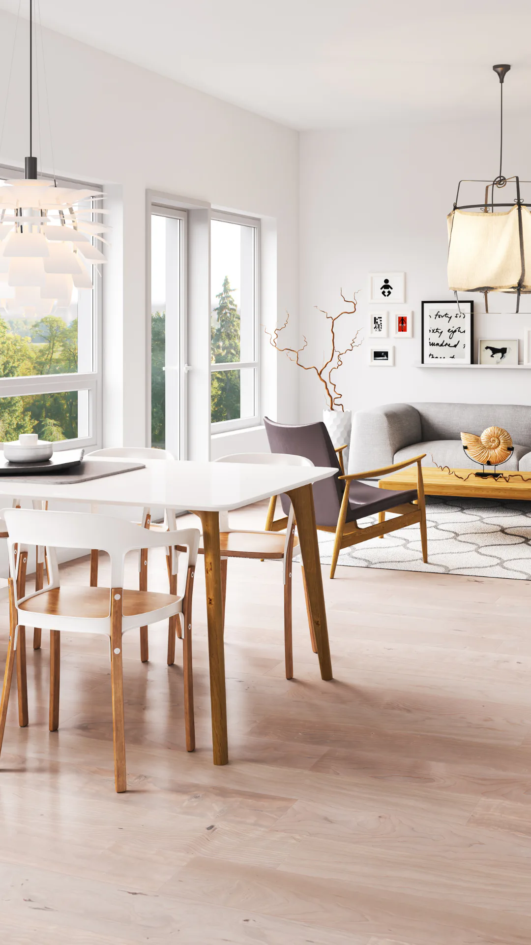Bright Scandinavian interior with wooden dining table, white chairs, gray sofa, pendant lighting, and large windows overlooking trees. Minimalist wall art and decorative branches accent the neutral...